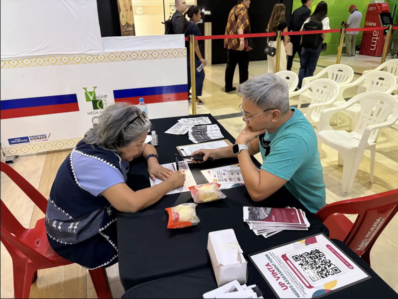 Prof. J. Aleta Villanueva, Program Chair of Diploma in and Masters of Arts in Social Studies Education, shares information about UPOU academic offerings with a participant.